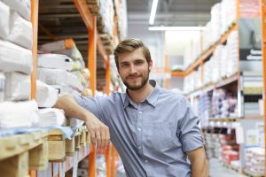 portrait of a smiling young warehouse worker working in a cash and carry wholesale store.